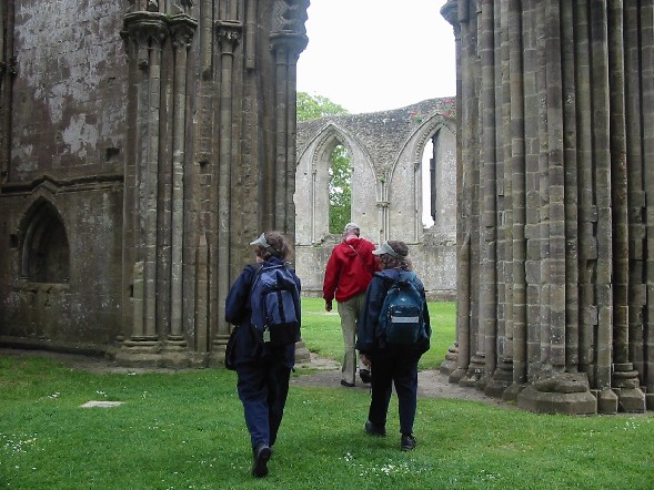 Image of Jan, MJ and Dan walk among the ruins of the main part of Abbey.